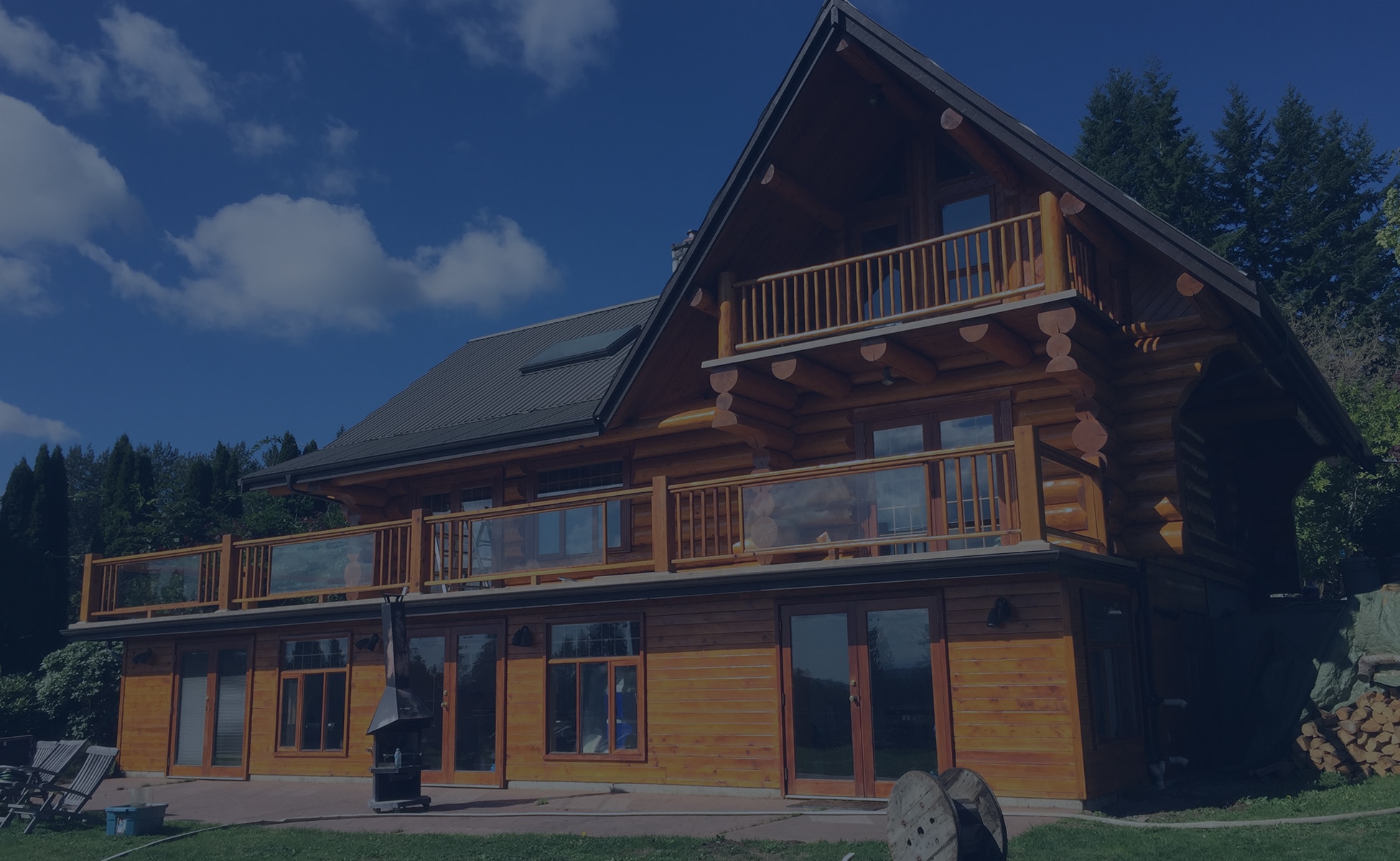 Superior Log Restorations — beautifully restored Fraser Valley log home with full chalet exterior, balconies, and natural wood finish